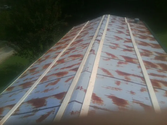 Rusted metal roof panels with new wood purlins before replacement — Storm Damage Roof Repair in North Attleboro by Roofing Brothers